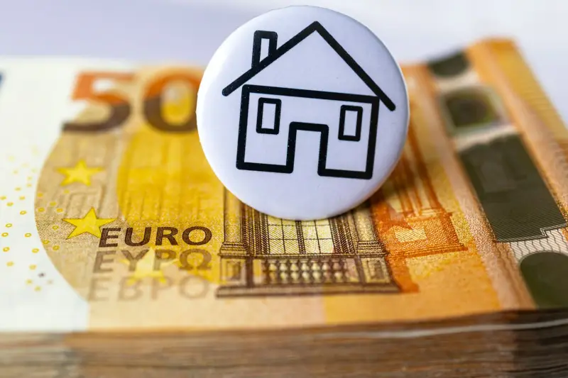Odznak s domem na svazku eurobankovek
