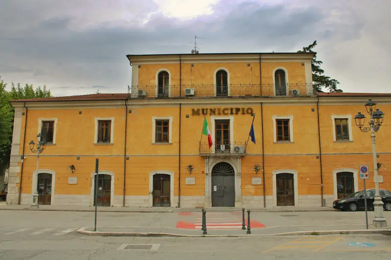 Žlutá budova s nápisem Municipio a italskou vlajkou
